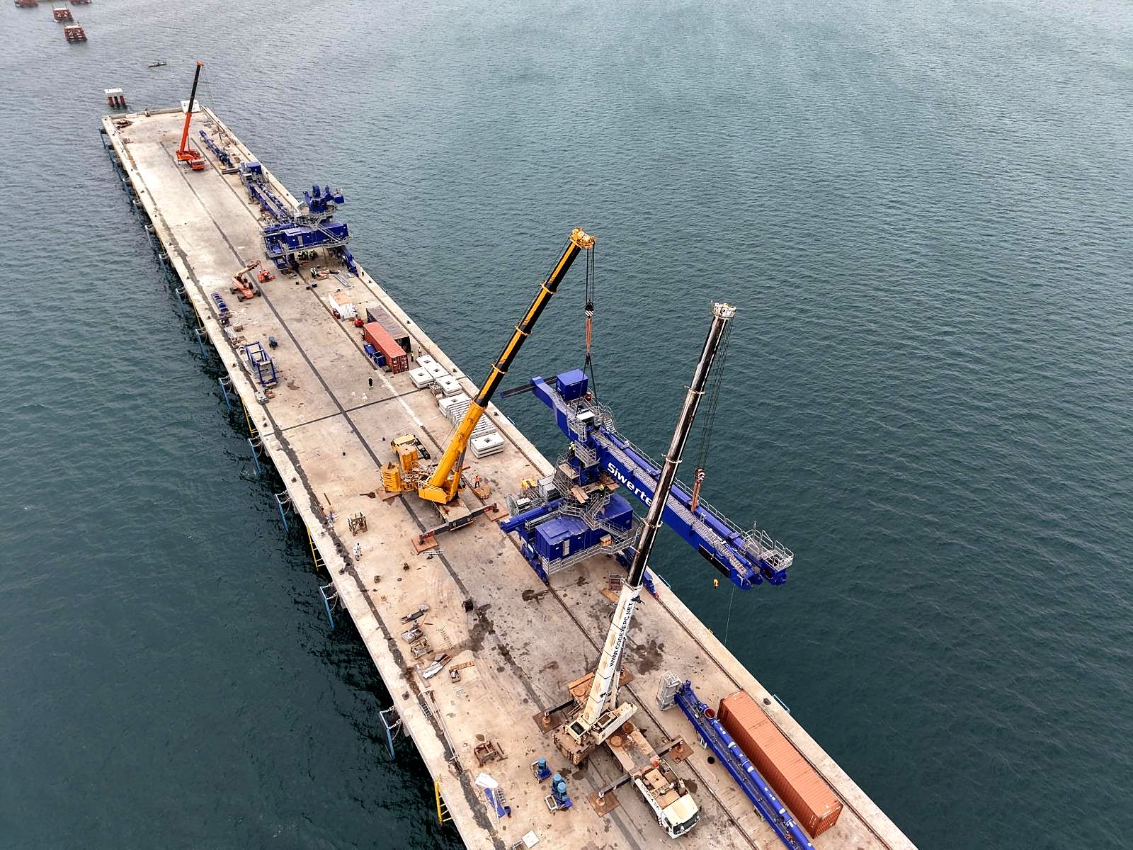 Assemblage d’une grue Siwertell sur la jetée, au moyen de deux grues mobiles